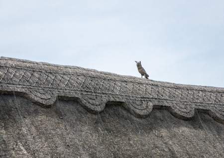 Thatched roof of an English cottage, with straw owl for pest deterrentの写真素材