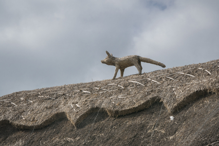 Thatched roof of an English cottage, with straw fox for pest deterrentの写真素材