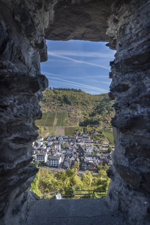 View of the town of Cochem framed by a stone window in Cochem Castle, Germanyの写真素材