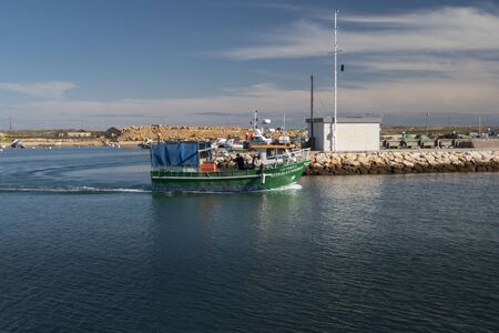 A small fishing boat going out to sea in Lagos, Portugalの写真素材