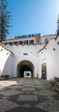 A couple walking through a pedestrian tunnel to the beach in Albufeira in the Algarve, Portugalのeditorial素材