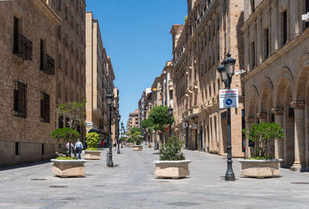 Street view of the city of Salamanca, Spain, with a temporary sign on a lampost because of Covid-19 that translates to -  pedestrians to walk to the rightのeditorial素材