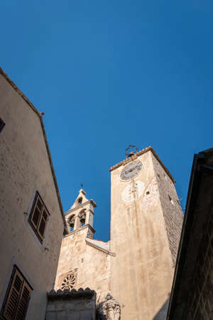 Clock tower and bell tower of the church of Saint Rocco in the old town of Omis, Croatiaの写真素材