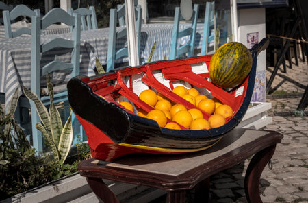 Oranges and melon on display in a model Portuguese fishing boatの写真素材