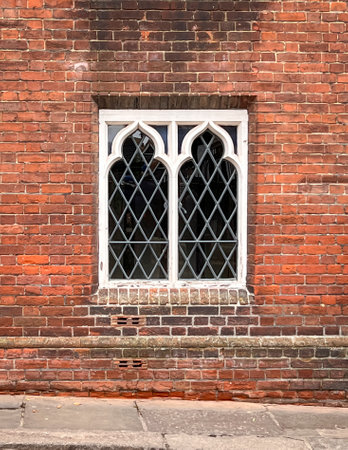 Ancient leaded window in a red brick wall, in the City of Canterbury, Kent, UKの写真素材