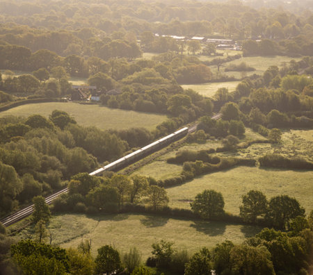 Aerial view of a train on a railway line in the countryside in Kent, UKの写真素材