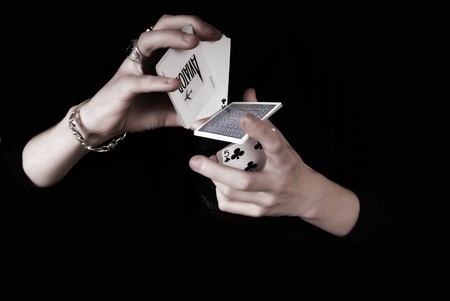 Young magicians hands holding a lot of play cards. black backgroundの写真素材