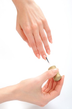 Beautiful woman hand applying nail laquer to her manicured nailsの写真素材