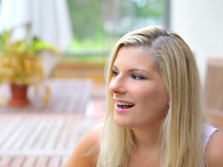 Young beautiful casual woman relaxing outdoors in the terrace of her homeの写真素材