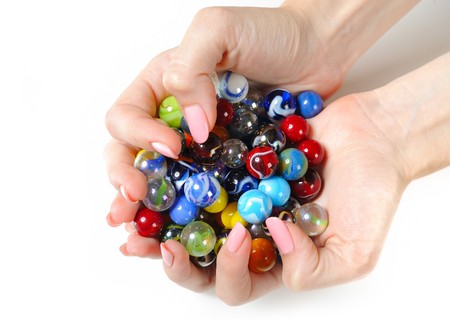 Beautiful hands with perfect manicure holding many colorfull ballsの写真素材