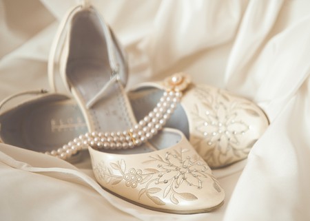 Beautiful luxury white wedding shoes with pearl necklaceの写真素材