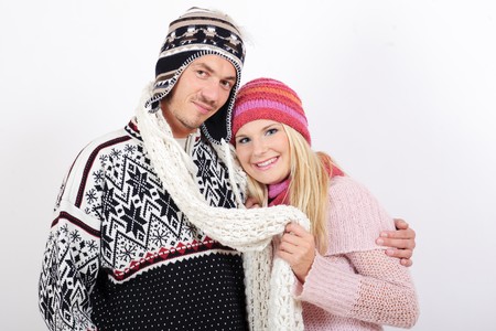 Handsome winter couple in warm clothes huging and kissingの写真素材