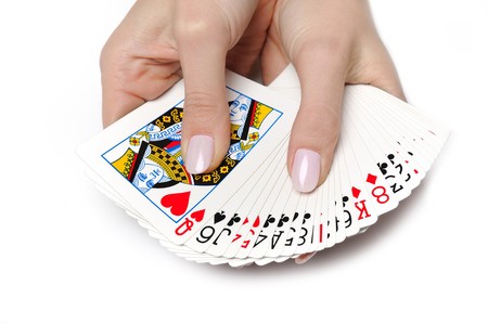 Beautiful hands with perfect  manicure holding a deck of playing cards. isolated on white background