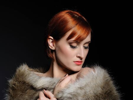 Beautiful woman with perfect skin and party make-up covered in furの写真素材