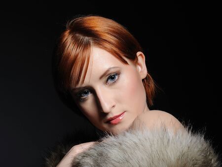 Beautiful woman with perfect skin and party make-up covered in furの写真素材