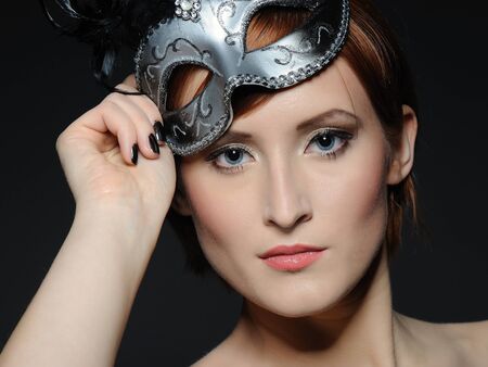 Beautiful woman with perfect party make-up in carnival maskの写真素材