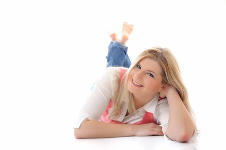 young casual smiling woman lying on the floor isolated on white background の写真素材