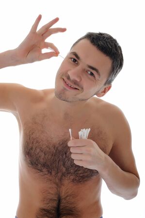 handsome young man cleaning ears with cotton pad stick. isolated on white backgroundの写真素材