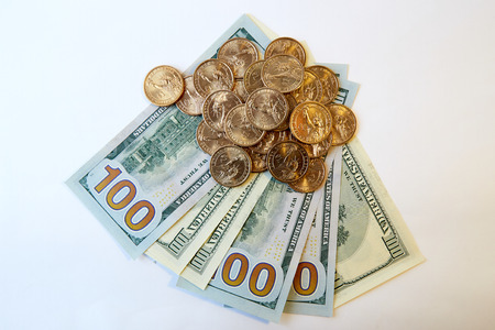Design element. Heap of yellow shine us dollars on a fan of hundred dollar bills. View from above....