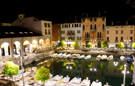 DESENZANO DEL GARDA, ITALY. 24th October 2017. The pretty Old Port at Desenzano del Garda, by night. Desenzano is an increasingly popular home base for independent travellers and tour groups.のeditorial素材