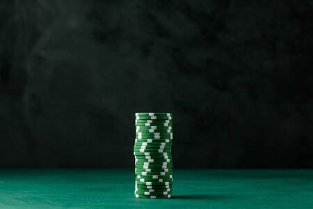 Stack of poker green chips on the table on a black backgroundの写真素材