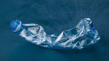 Plastic bottle on dark blue background. The concept of ecology.