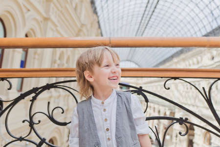 One little emotional boy walking in big supermarketの写真素材