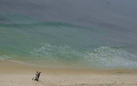 People walking through the beach in Varkala, Kerala, India
