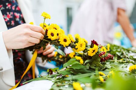 weaving a wreath of wild flowers in a hand