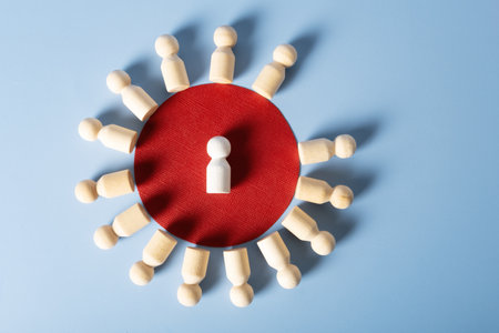 Wooden figures of people are placed in a circle, in the center of which is a white figure. The concept is the center of attention of society.の写真素材