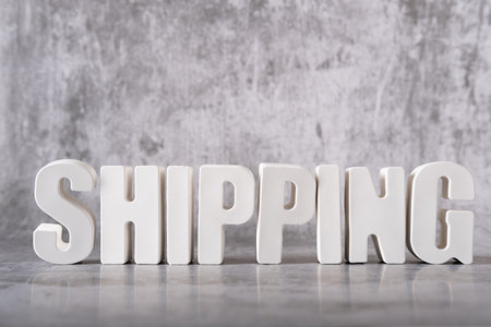 Word Shipping made from white concrete letters on the gray background.の写真素材