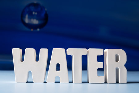Word Water made from white concrete letters on the blue background.の写真素材