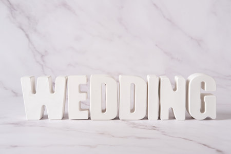 Word Wedding made from white concrete letters on the blue background.の写真素材