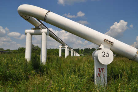 The main oil pipeline of a high pressure in a summer landscape under clouds.の写真素材