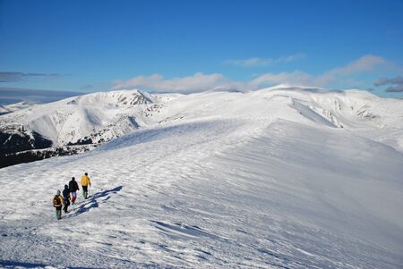 A winter mountain landscape with tourists and far topsの写真素材