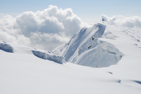 White snow mountain top in a winter landscape under clouds.の写真素材