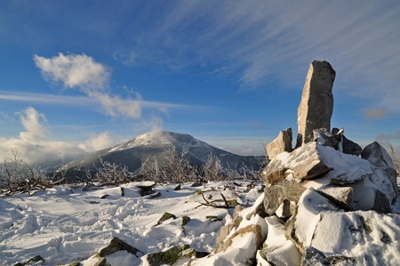 A pyramid from stones at mountain top in a winter landscape with clouds. の写真素材