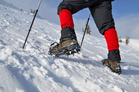Feet of the tourist in grapnels on a winter hillsideの写真素材