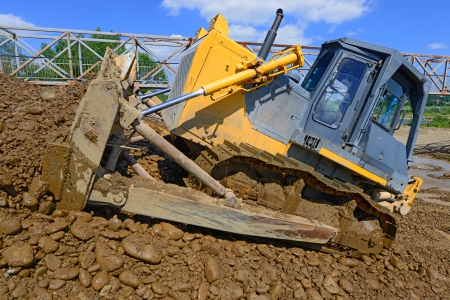 Bulldozer at work to strengthen the shoreline of the river