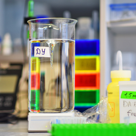 Big beaker with buffer solution on a magnetic stirrer. Laboratory magnetic stirrer creates a whirlpool in a big beaker with buffer solution.の写真素材