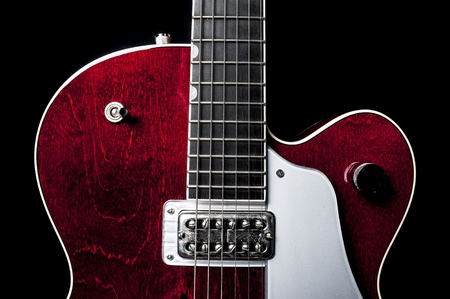 Shiny and sleek red electric guitar again a black back drop