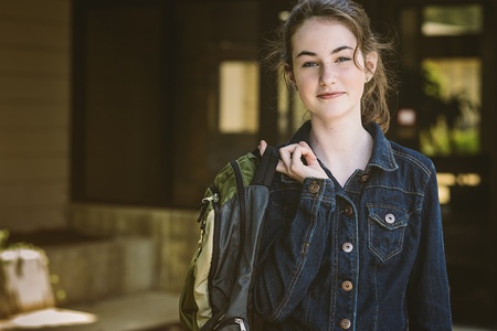 Teen-aged female student heads back to school with her back pack