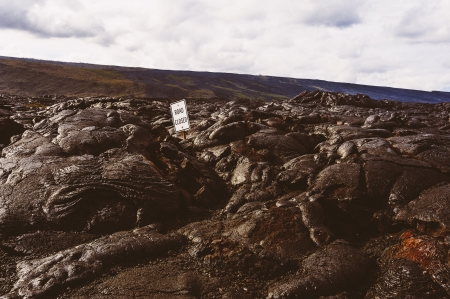 Road closed sign which has been nearly buried by a lava flow, in Volcano National Park Hawaiiの写真素材