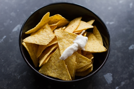 bowl of tortilla chips on a black kitchen counterの写真素材