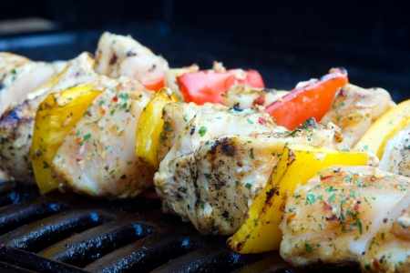 chicken and pepper kebabs slowly cooking on the barbecueの写真素材