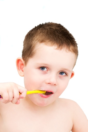 Little boy in the bath tub brushing teeth isolatedの写真素材
