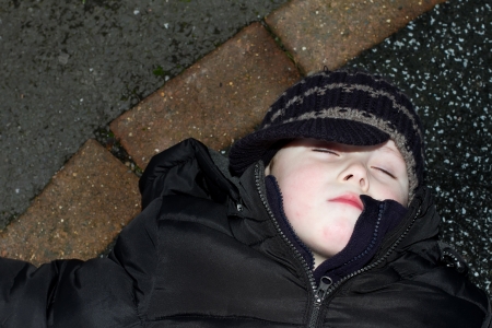 litte boy knocked down  outside oon tarmacの写真素材