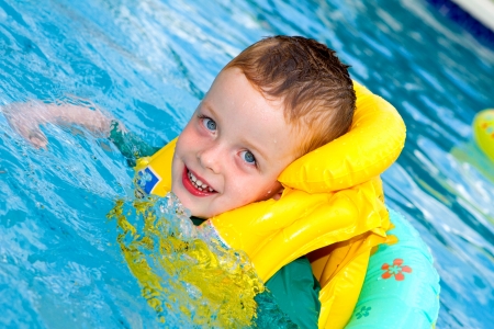little boy swimming with life vest onの写真素材