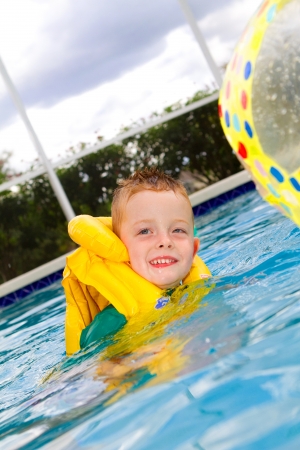 little boy swimming with life vest onの写真素材