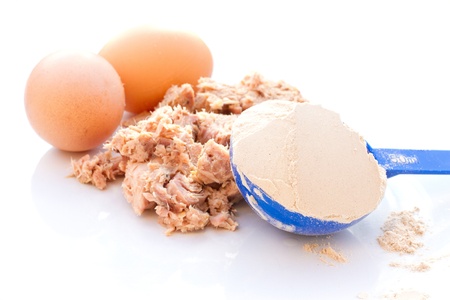 Tuna, egg and whey protein powder on a white plateの写真素材